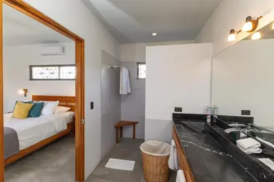 a bathroom with a bed and a sink and a mirror at Secret Mountain Top 3BR Casa Colibrí private pool in Quepos