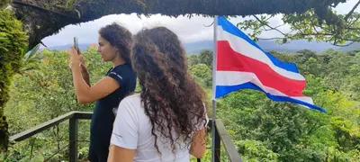 two women standing in front of a flag at Río Celeste Nature View in Upala