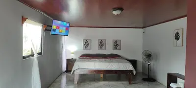 a bedroom with a bed and a tv on the ceiling at Río Celeste Nature View in Upala