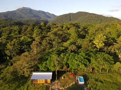 an aerial view of a house and a truck in a forest at Río Celeste Nature View in Upala