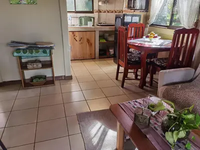 a living room with a table and chairs and a kitchen at Greenhouse Lofts Miravalles in Aguas Claras