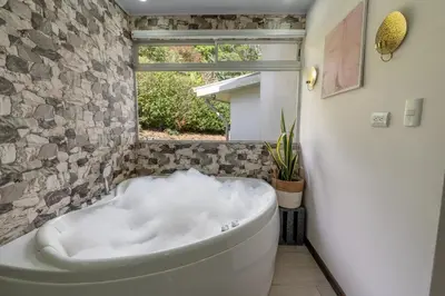 a white bath tub in a bathroom with a window at House of Turri Suite Views Terrace & Jacuzzi in Verbena Norte