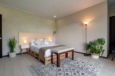 a bedroom with a bed and two plants and two lights at House of Turri Suite Views Terrace & Jacuzzi in Verbena Norte