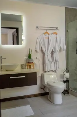 a bathroom with a toilet and a sink and a mirror at House of Turri Suite Views Terrace & Jacuzzi in Verbena Norte