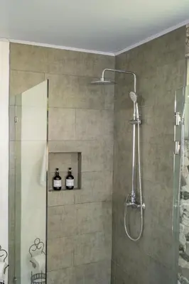 a bathroom with a shower with two bottles on a shelf at House of Turri Suite Views Terrace & Jacuzzi in Verbena Norte