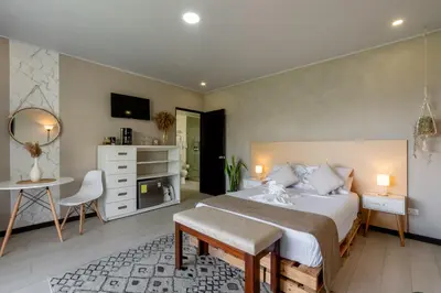 a bedroom with a large bed and a table and chair at House of Turri Suite Views Terrace & Jacuzzi in Verbena Norte