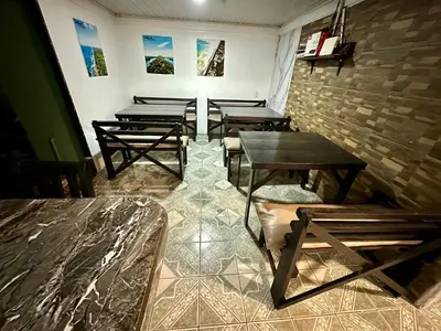 a group of tables in a room with windows at Caribbean View House in Tortuguero