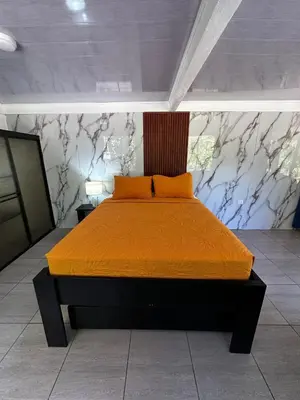a bedroom with a bed with an orange bedspread at Caribbean View House in Tortuguero