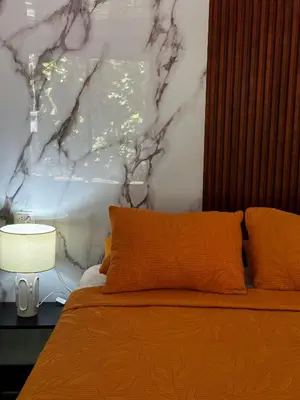 a bedroom with an orange bed with a wall at Caribbean View House in Tortuguero