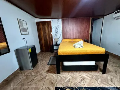 a bedroom with a bed with a yellow bedspread at Caribbean View House in Tortuguero