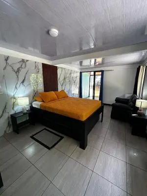 a bedroom with a bed with orange pillows in it at Caribbean View House in Tortuguero
