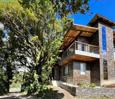 a brick house with a wooden roof at Cougar Monteverde in Monteverde Costa Rica