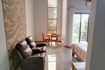 a living room with a leather couch and a table at Cougar Monteverde in Monteverde Costa Rica