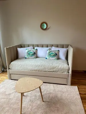 a couch in a living room with a clock on the wall at Iluminar Beachfront Suites in Nosara