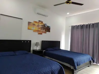 a bedroom with two beds and a ceiling fan at Casa Coral Tamarindo in Guatemala