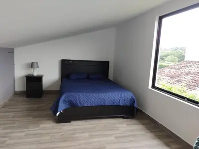 a bedroom with a bed and a large window at Casa Coral Tamarindo in Guatemala