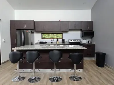 a kitchen with a island with bar stools in it at Casa Coral Tamarindo in Guatemala
