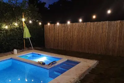a backyard swimming pool at night with a fence at Casa Coral Tamarindo in Guatemala