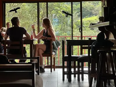 two people sitting at a table with glasses of wine at Monteverde Monkey Hostel in Monteverde Costa Rica