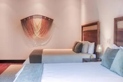 a hotel room with two beds and a mirror at Pinilla Flor de Malinche 15 in Tamarindo