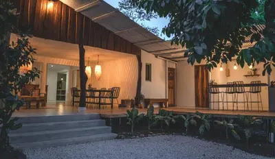 a porch of a house with a table and chairs at Cuatro Vientos Lodge & Apartments - Santa Teresa, CR in Santa Teresa Beach