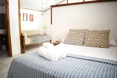 a bedroom with a bed with towels on it at Cuatro Vientos Lodge & Apartments - Santa Teresa, CR in Santa Teresa Beach