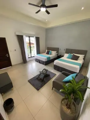 a hotel room with two beds and a fan at Hotel Naoz in Manuel Antonio