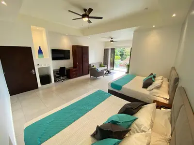 a bedroom with two beds and a ceiling fan at Hotel Naoz in Manuel Antonio