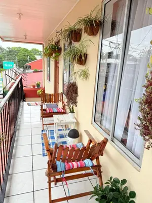 a balcony with two chairs and a table and windows at Sweet Home Carrión in Fortuna