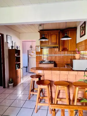 a kitchen with wooden stools and a counter top at Sweet Home Carrión in Fortuna