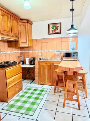 a kitchen with wooden cabinets and a table and chairs at Sweet Home Carrión in Fortuna