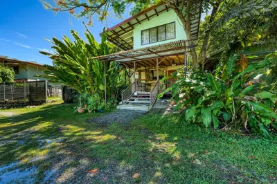 an exterior view of a house with a yard at Bamboo River House and Hotel in Dominical