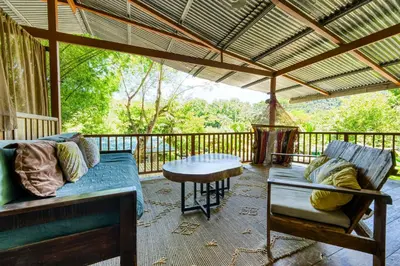 a screened in porch with a couch and a table at Bamboo River House and Hotel in Dominical