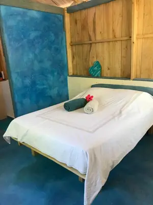 a bed with two pillows on top of it at Cabañas Casa Soley in Puerto Soley
