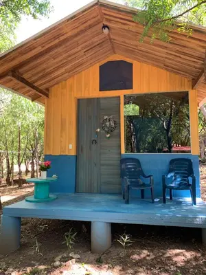 a small house with two chairs and a porch at Cabañas Casa Soley in Puerto Soley