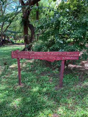 a sign in the grass in a park at Cabañas Casa Soley in Puerto Soley