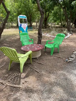 three chairs and a table in a park at Cabañas Casa Soley in Puerto Soley