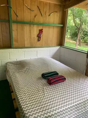 a bed in a room with two bags on it at Cabañas Casa Soley in Puerto Soley