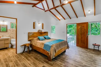 a bedroom with a bed and a bathroom at Lost Pools Bungalow at Sloth in Uvita