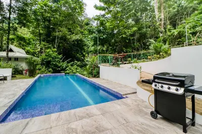 a backyard with a swimming pool and a grill at Lost Pools Bungalow at Sloth in Uvita