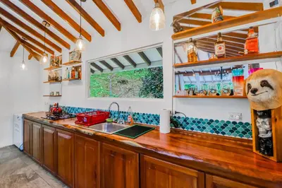 a kitchen with a wooden counter top and a sink at Lost Pools Bungalow at Sloth in Uvita