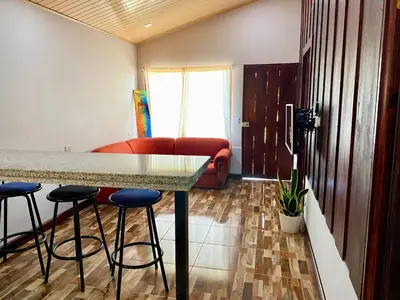a kitchen with a table and stools in a room at La Cabaña de Merce in Tanque