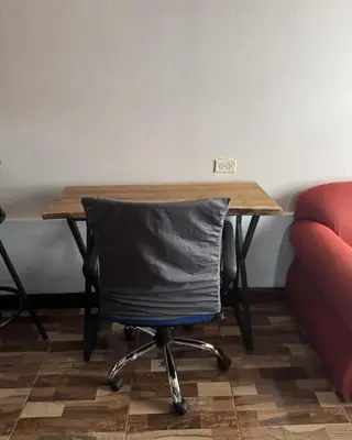 a table with a chair with a pillow on it at La Cabaña de Merce in Tanque