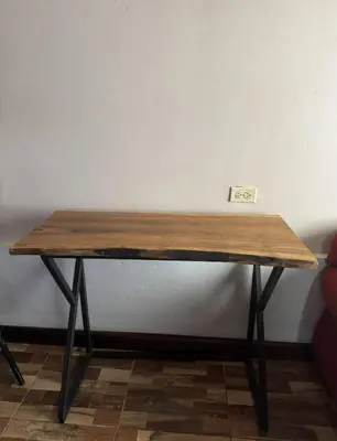 a wooden table sitting in a room next to a wall at La Cabaña de Merce in Tanque