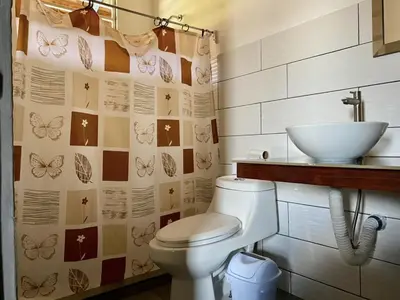 a bathroom with a toilet and a sink at La Cabaña de Merce in Tanque