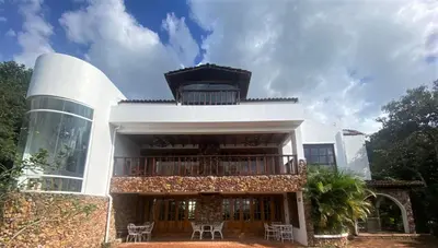 a large white building with a balcony and chairs at Hotel Don Ernesto By La Chimba in San José