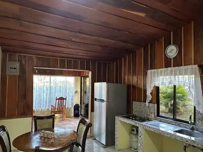 a kitchen with a table and a refrigerator at Cabaña Rana Verde in Monteverde Costa Rica