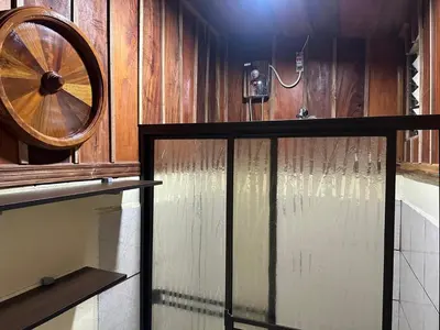 a room with a wooden wall with a spinning wheel at Cabaña Rana Verde in Monteverde Costa Rica