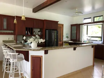 a kitchen with a large island with a counter top at Villa Corazón - private beach at Lake Arenal in Nuevo Arenal