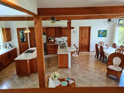 a kitchen and living room with a table and chairs at Villa Corazón - private beach at Lake Arenal in Nuevo Arenal